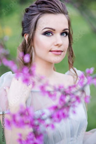 Portrait of a beautiful girl in flowers. Professional makeup. Fashion model in work. Wedding make-up. Portrait of a stylish bride.