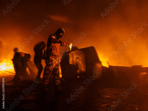 Obraz na plátne Street Protestant with a Molotov cocktail against a fire