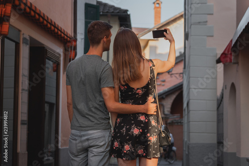 Wallpaper Mural young couple in love taking a selfie during shopping in an alley in ascona Torontodigital.ca