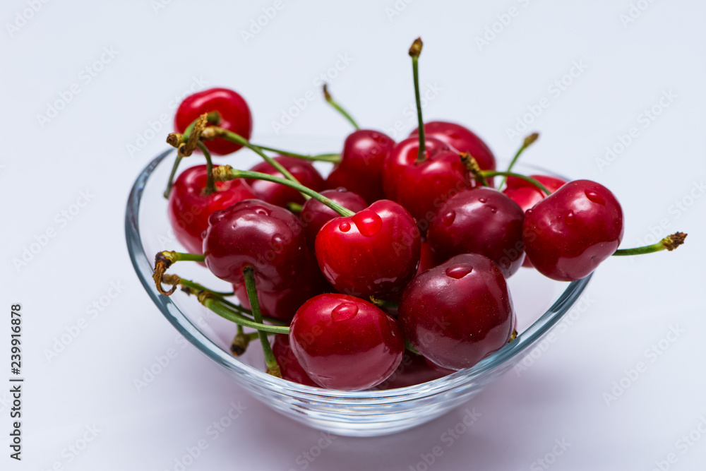 The glass bowl filled with ripe cherries The glass bowl filled with ripe cherries