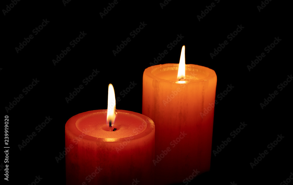 Red an orange candle before the dark with black background Red an orange candle before the dark with black background
