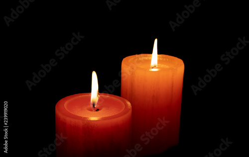 Red an orange candle before the dark with black background