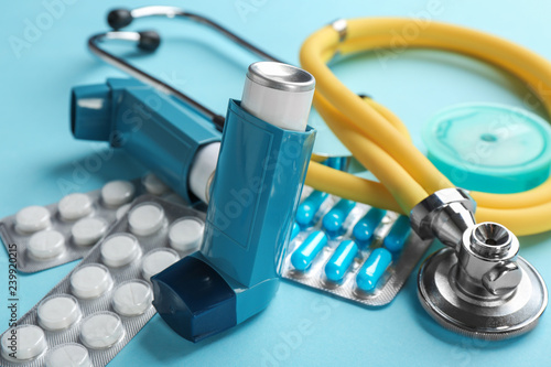 Obraz na płótnie Asthma inhalers, stethoscope and pills on color background, closeup