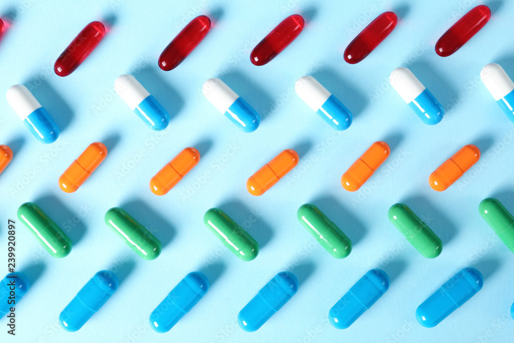 Different bright pills on color background, flat lay Different bright pills on color background, flat lay
