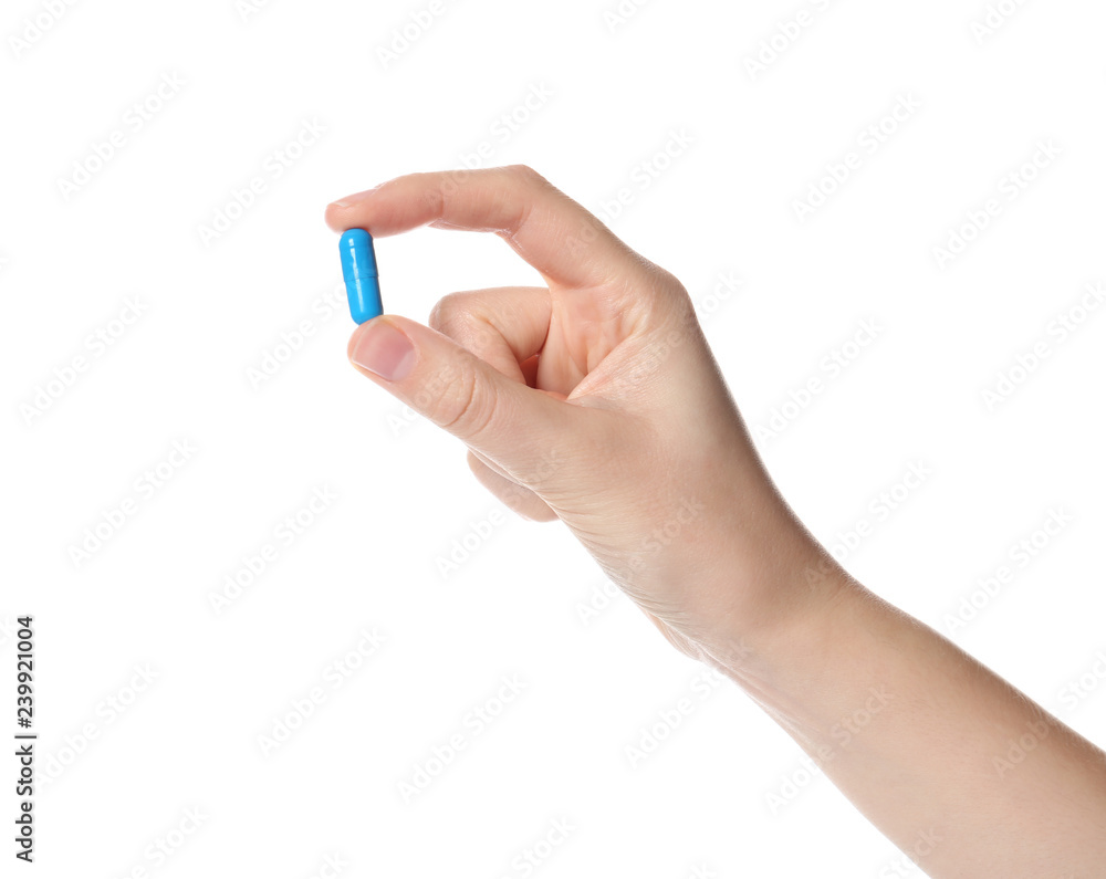 Woman holding color pill on white background, closeup Woman holding color pill on white background, closeup
