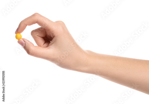 Woman holding color pill on white background, closeup