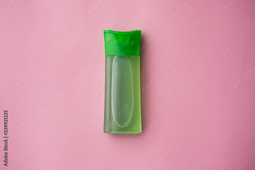 Green cleansing gel for the face and sponge for cleansing the skin on a pink background. Cosmetic products. Skin care. selective focus Green cleansing gel for the face and sponge for cleansing the skin on a pink background. Cosmetic products. Skin care. selective focus
