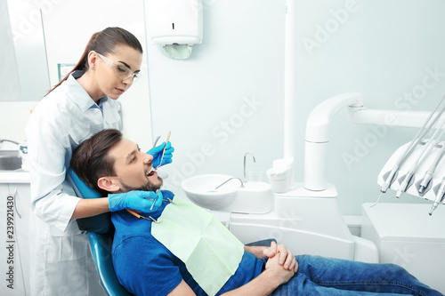 Professional dentist working with patient in modern clinic. Space for text