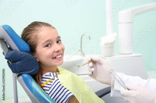 Professional dentist working with little patient in modern clinic