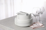 Set of clean dishes on table against blurred background. Space for text