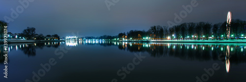 night cityscape near the lake with bright lights, panorama