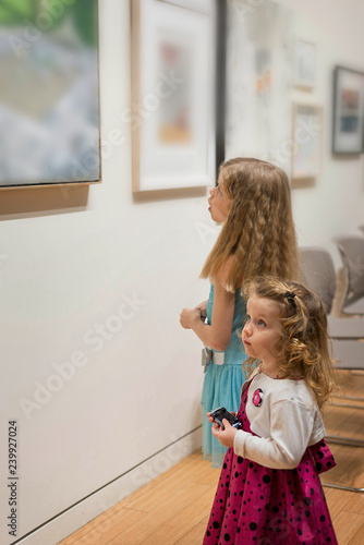 Two little girls are looking at the pictures in the Art Gallery 