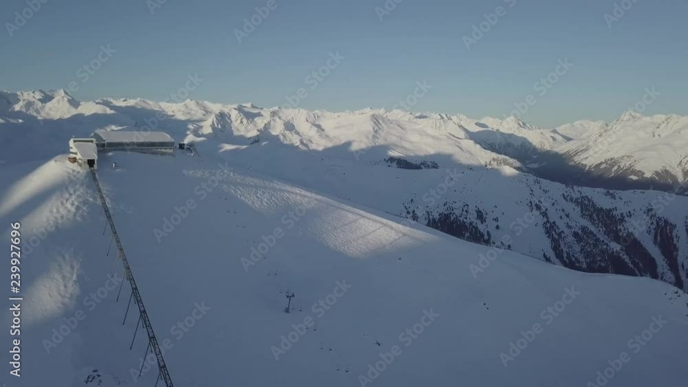 A drone shot of a ski resort, with mountains in the back at nice weather conditions. A drone shot of a ski resort, with mountains in the back at nice weather conditions.