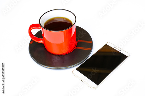 Red coffee mug A mobile phone is placed next to it. isolation On a white background