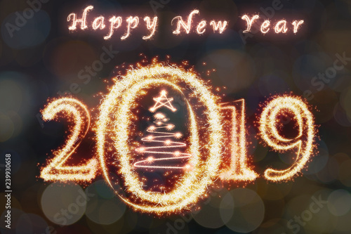 Happy new year 2019 and christmas tree written with Sparkle firework on photo blurred bokeh background, celebration and greeting cards concept