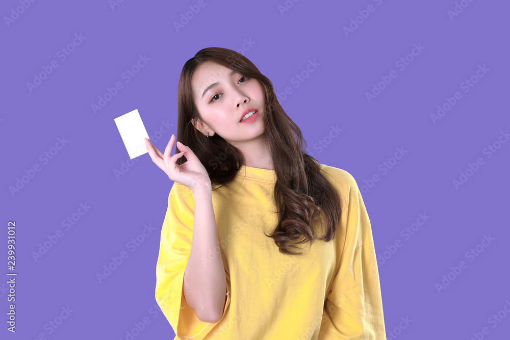 Korean woman use blank credit card to pay online shopping, yellow t-shirt clothing, purple background Korean woman use blank credit card to pay online shopping, yellow t-shirt clothing, purple background