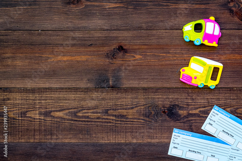 accessories for treveling with children, tickets and toys on wooden background top view mock-up photo