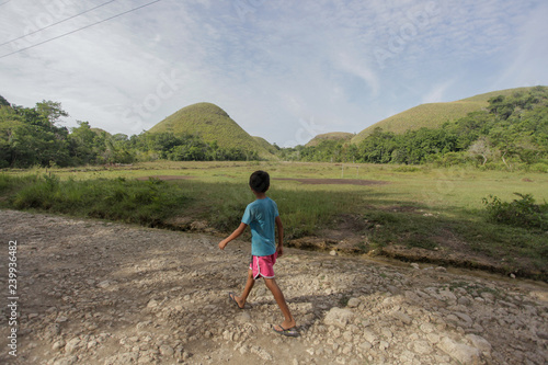 Boy walking along Chocolate Hills of Bohol