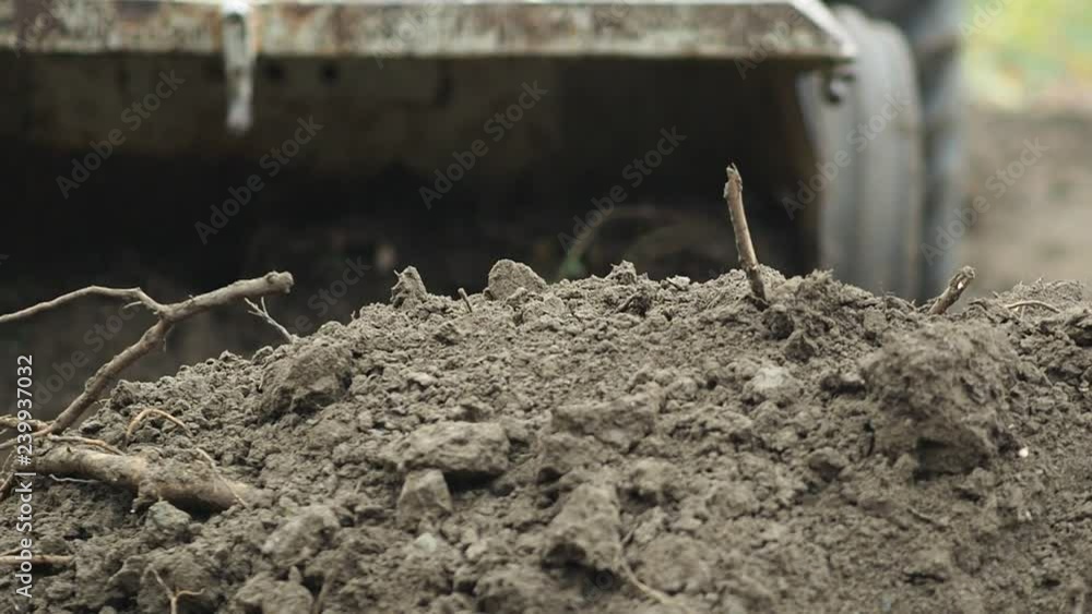 Soil being moved by a tractor driven by a a small scale, organic farmer  in Johnston, Rhode Island