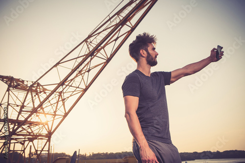 Young man taking selfie at sundown