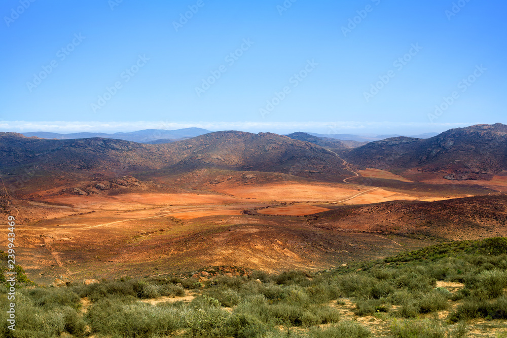 Landscape panorama mountain valley, rural road among green and yellow field on the Drakensberg mountains and blue sky background top view, wild South Africa travel