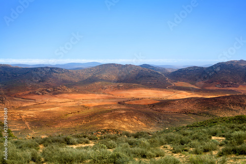 Landscape panorama mountain valley, rural road among green and yellow field on the Drakensberg mountains and blue sky background top view, wild South Africa travel