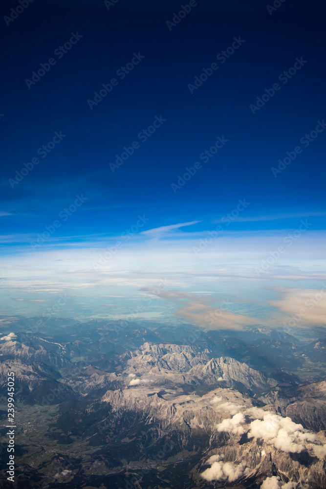 Blue sky and mountain landscape over Europe from an airplane window