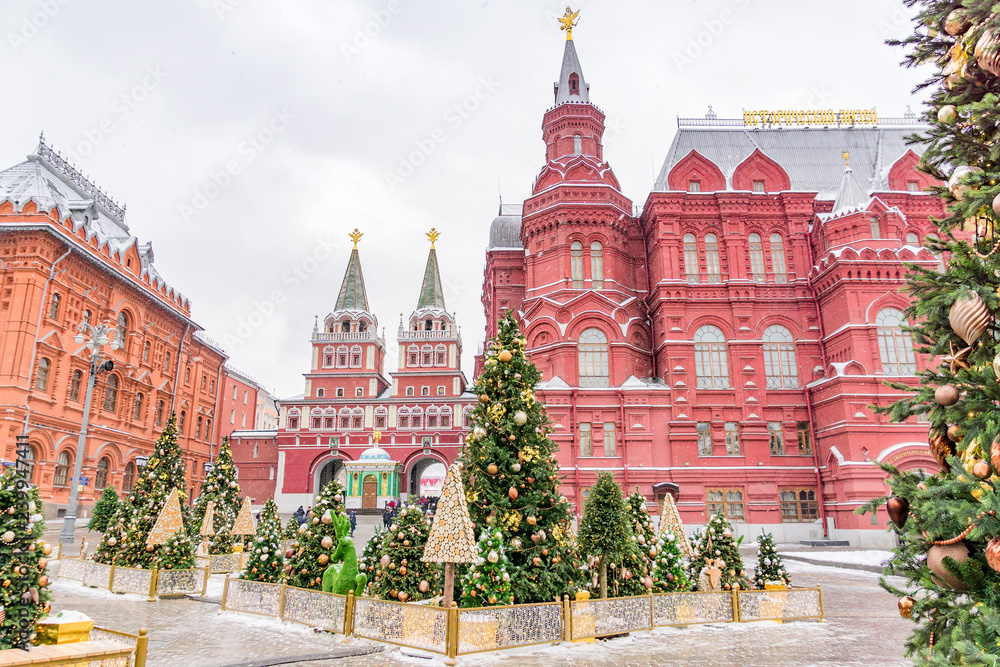 Moscow, Russia -  Christmas decorated Manezhnaya Square in a snowy day. Many christmas trees on Red Square background