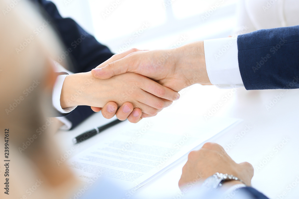 Group of business people or lawyers shaking hands finishing up a meeting , close-up. Success at negotiation and handshake concepts Group of business people or lawyers shaking hands finishing up a meeting , close-up. Success at negotiation and handshake concepts