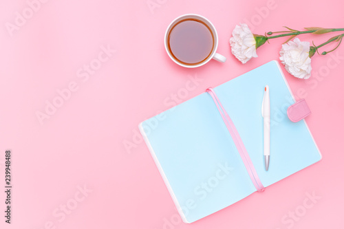 workspace desk styled design office supplies, hot tea and white flower on pink pastel background minimal style
