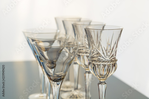 Decorative wine and martini glasses are set up in verticle rows displaying beautiful details of the glass.