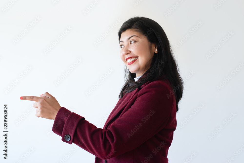 Excited cheerful girl presenting new information. Side view of overjoyed young Asian woman pointing finger at copy space away. Presentation concept Excited cheerful girl presenting new information. Side view of overjoyed young Asian woman pointing finger at copy space away. Presentation concept