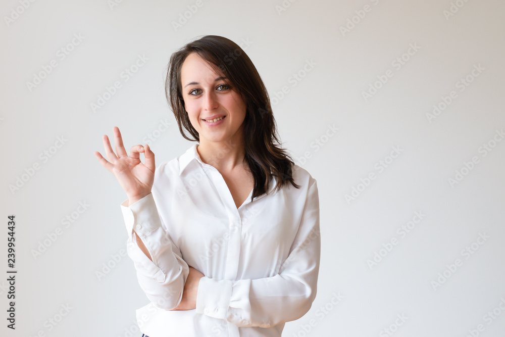 Content female customer gesturing okay. Confident young woman showing fingers in OK sign. Positive feedback concept Content female customer gesturing okay. Confident young woman showing fingers in OK sign. Positive feedback concept