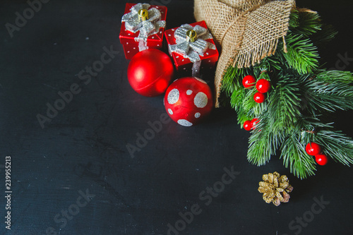 green christmas tree decoration with red decor on wooden black background