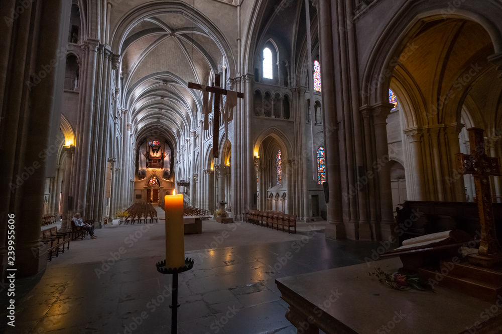 Interior of catholic cathedral, candle at foreground
