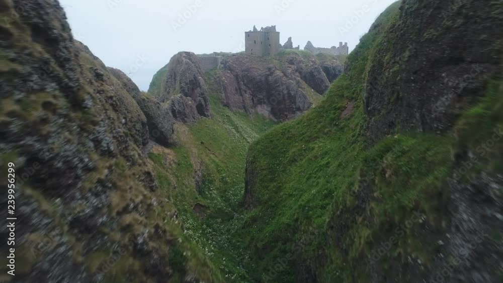 Drone shot approaching crumbling ruins of abandoned medieval Dunnottar castle, built on a spectacular location on the East coast of Scotland Drone shot approaching crumbling ruins of abandoned medieval Dunnottar castle, built on a spectacular location on the East coast of Scotland