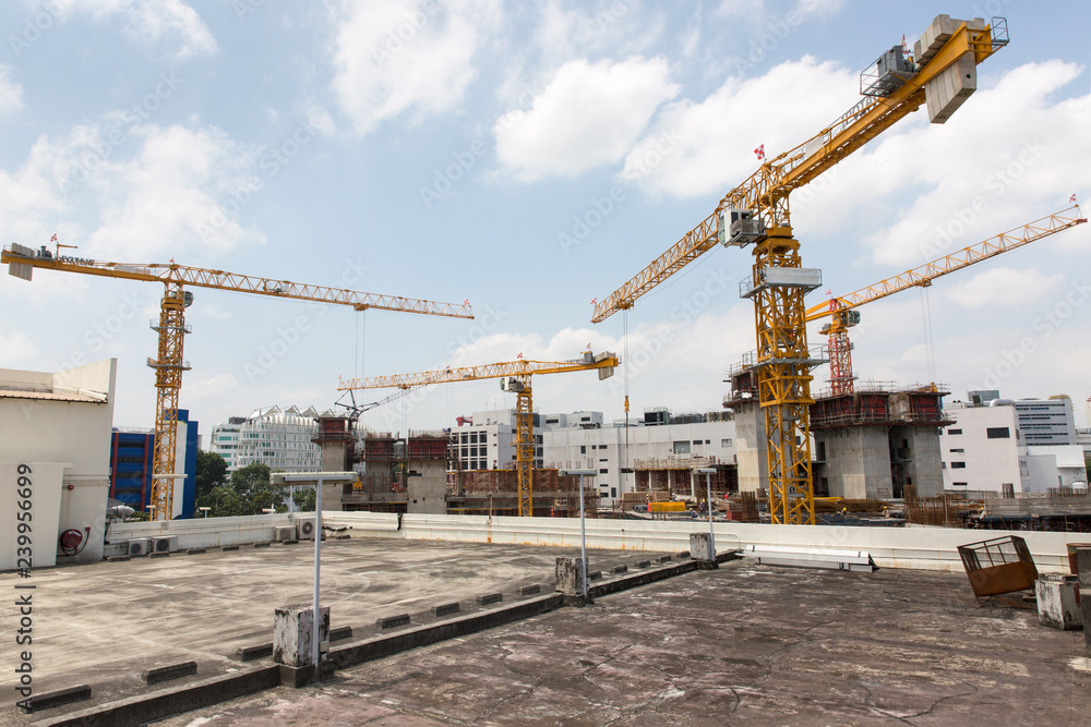 Construction Cranes Against Blue Sky