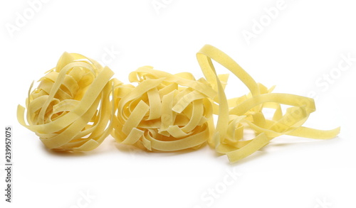 Raw tagliatelle pasta noodles isolated on white background