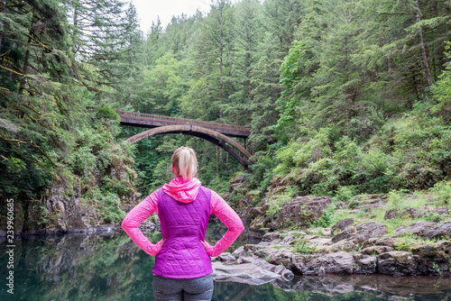 Female Hiker Looking at Bridge in Nature. Woman hiking outdoors, Active lifestyle concept.
