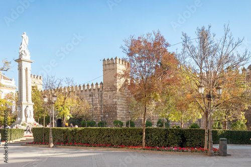 Seville, Spain - December 15, 2018: Triumph Square (Plaza del Triunfo) with The Alcazar of Seville ("Reales Alcazares de Sevilla" or Royal Alcazars of Seville) is a royal palace in Seville, Spain