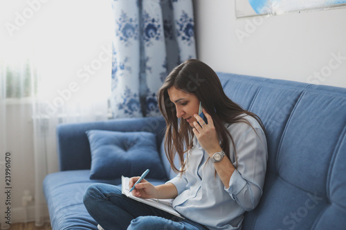 Cute caucasian girl talking on phone in real room