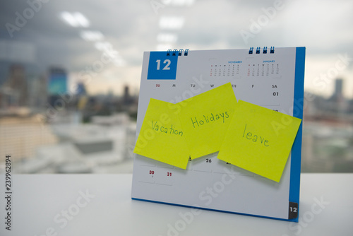 Vacation, holiday and leave on paper note stick on the calendar of December for year end holidays concept