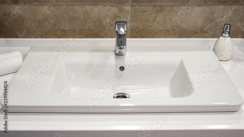 a silver tap in a white bathroom