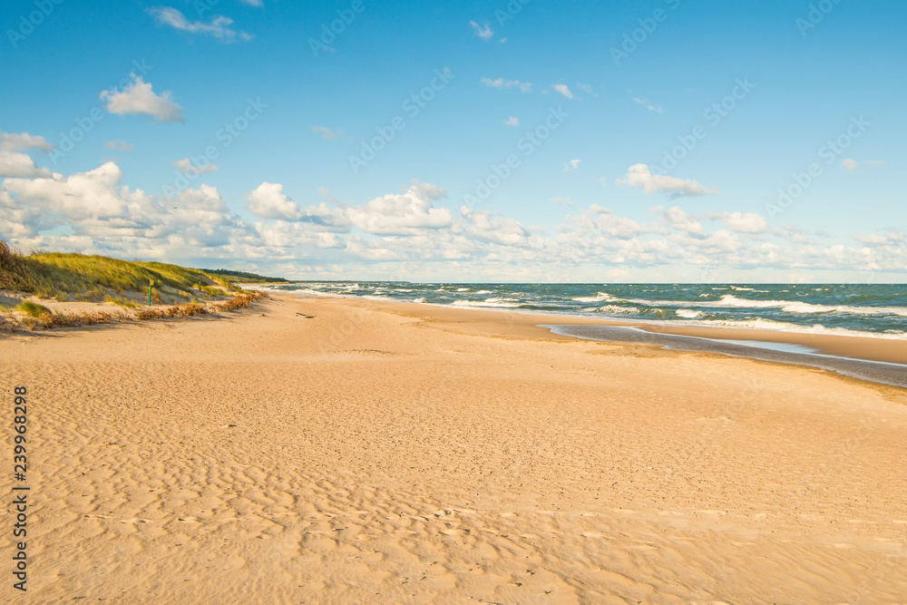 beach of the Baltic Sea with blue sky and clouds