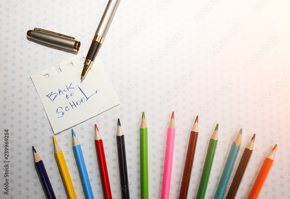 Naklejka premium Color pencils lying on cute spotted background with dots. Back to school concept and sign written with a pen. Colorful art studying and painting process. Copy space place for postcard wish.