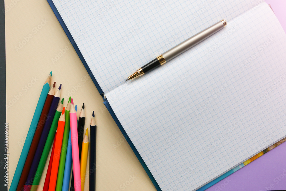 Color pencils lying on pastel purple and beige background near squared notebook. Back to school concept. Colorful art studying and painting process. Copy space place for postcard wish. Color pencils lying on pastel purple and beige background near squared notebook. Back to school concept. Colorful art studying and painting process. Copy space place for postcard wish.