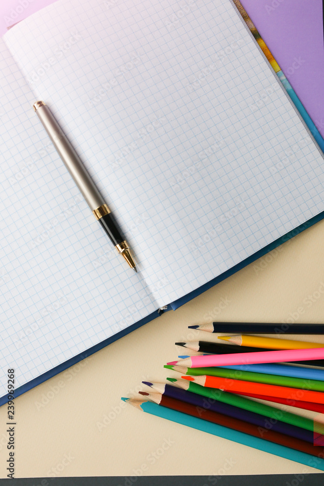 Color pencils lying on pastel purple and beige background near squared notebook. Back to school concept. Colorful art studying and painting process. Copy space place for postcard wish. Color pencils lying on pastel purple and beige background near squared notebook. Back to school concept. Colorful art studying and painting process. Copy space place for postcard wish.