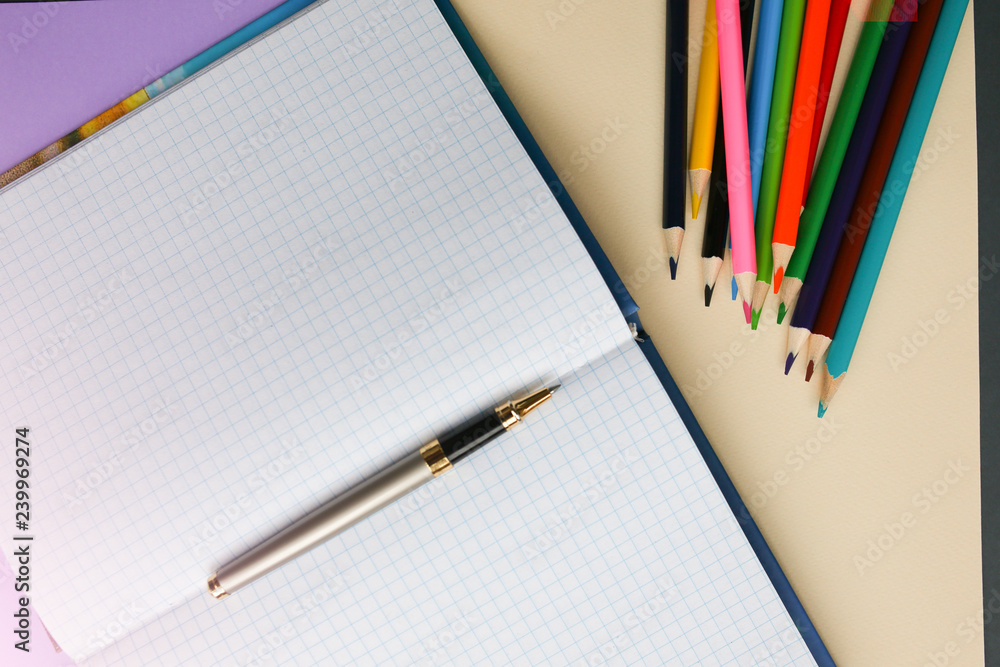 Color pencils lying on pastel purple and beige background near squared notebook. Back to school concept. Colorful art studying and painting process. Copy space place for postcard wish. Color pencils lying on pastel purple and beige background near squared notebook. Back to school concept. Colorful art studying and painting process. Copy space place for postcard wish.