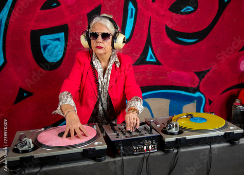 grandma dj in front of graffiti wall