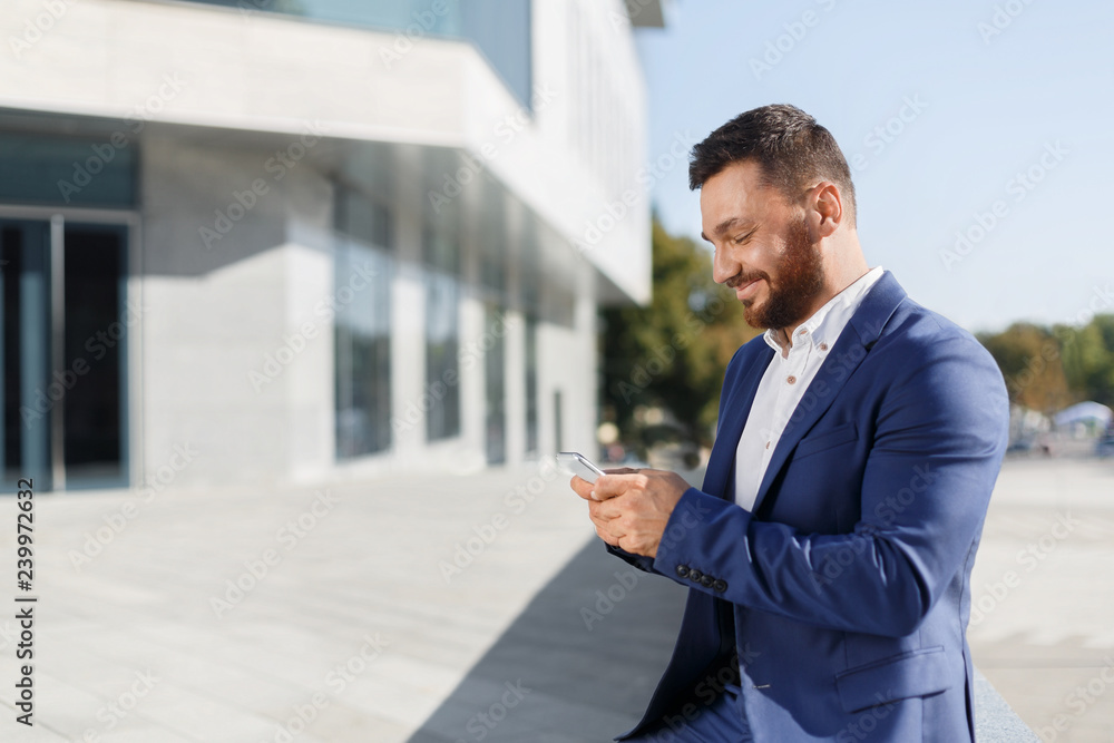 Businessman using mobile phone app outside at office Businessman using mobile phone app outside at office